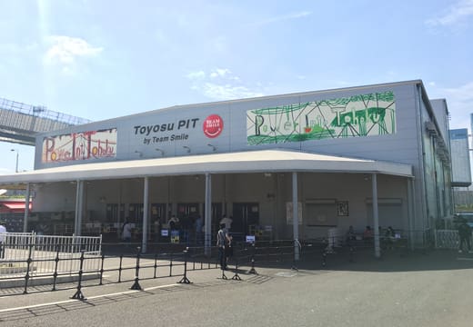 The long low hall and sign of Toyosu PIT by the Toyosu waterfront on a sunny day