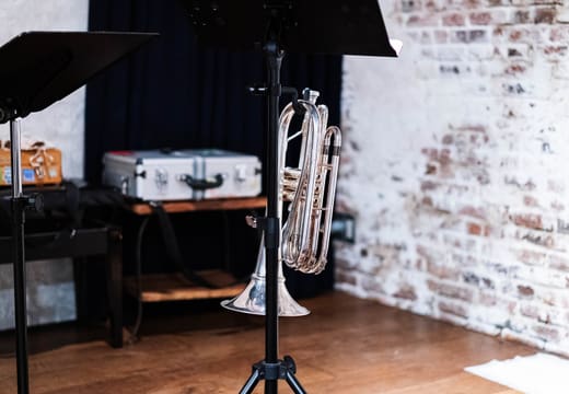 Brick-walled stage of live space ZIMAGINE in Aoyama set with music stands and a euphonium